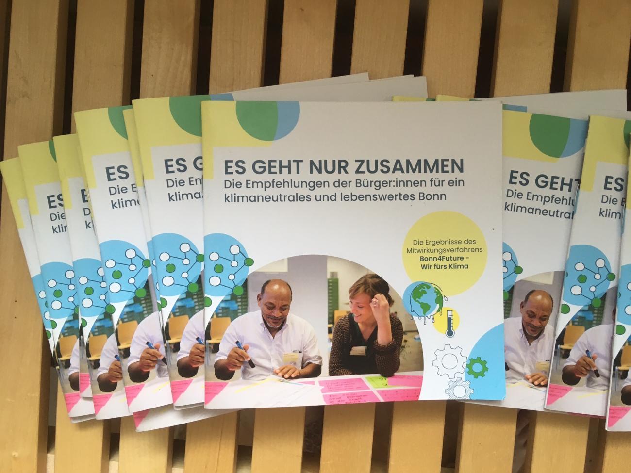 img_5349.jpg mehrere Exemplare der Mini-Broschüre zum Klima-Aktionsplan der Bürger:innen